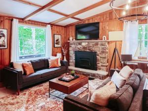 ein Wohnzimmer mit einem Sofa und einem Kamin in der Unterkunft Stylish and Cozy Cabin, Walking Distance to Big Bass Lake in Gouldsboro