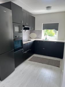 a kitchen with black cabinets and a sink and a window at Villa Elme in Växjö