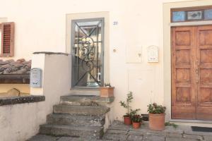 un edificio con una puerta y escaleras con macetas en Appartamento toscano Pelago - Firenze en Pelago