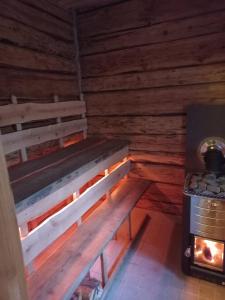 a wooden bench in a room with a stove at Sagadi Traditional House With The Sauna And Free Parking in Sagadi