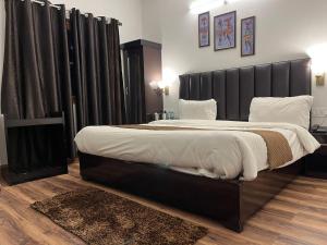 a bedroom with a large bed with a black headboard at Cedar Woods Resort in Nainital