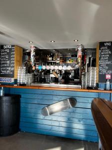 a bar with a wooden counter with a metal spoon at LOGIS HOTEL - La Petite Rade in Le Havre