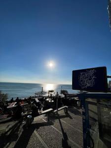 a sign on a beach with the ocean in the background at LOGIS HOTEL - La Petite Rade in Le Havre