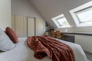 a bedroom with a bed with a red blanket on it at Guesthouse Polderlicht in Blankenberge