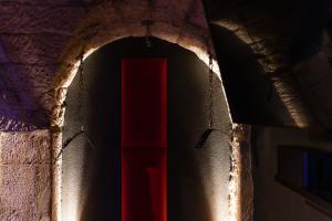 a dark tunnel with a red door in a wall at Liebesgewölbe in Pirna