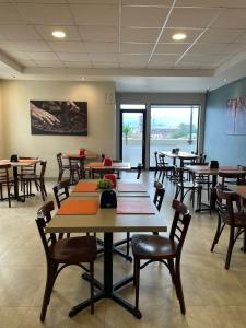 un comedor con mesas, sillas y ventanas en Hotel Manso de Velasco, en San Fernando