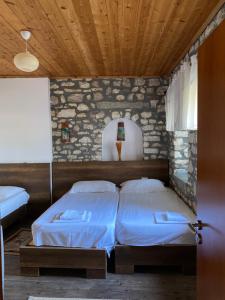 1 dormitorio con 2 camas y techo de madera en Aria Baci Guest House, en Berat 16 fotos más