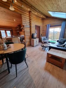 a living room with a table and a couch at Finse Woning op Camping De Tulpenweide in Breezand