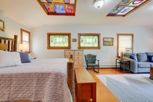 ein Schlafzimmer mit einem Bett und einem Sofa sowie Buntglasfenstern in der Unterkunft Unique Cape Cod Vacation Rental with Yard and Fire Pit in Brewster