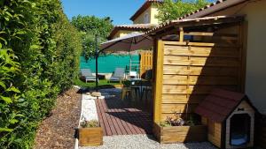 a backyard with a wooden dog house and an umbrella at Chez Florence et Bruno in Saint-Cyr-sur-Mer