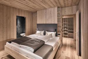 a bedroom with a large bed and wooden walls at Waldchalet mit Jacuzzi in Racines
