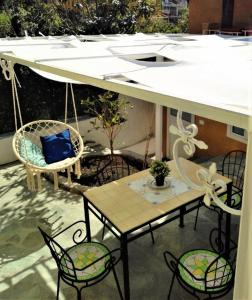 un patio con mesa, sillas y un columpio en Il Nespolo, en Maratea