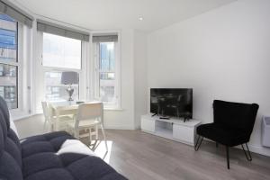 - un salon avec un canapé, une table et une télévision dans l'établissement The Stafford Apartments, à Bournemouth