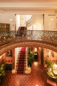 an ornate staircase in a building with plants at Hospes Infante Sagres Porto in Porto