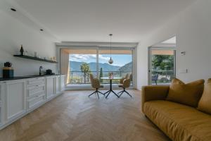 a living room with a couch and a table with chairs at Schloss Plars wine & suites in Lagundo