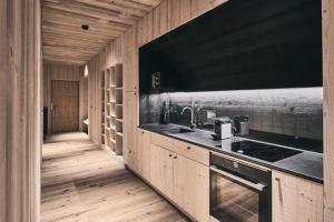 cocina con fregadero y fogones en Ruhiges Waldchalet, en Racines