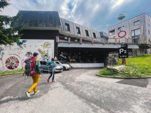 dos personas caminando por una calle en frente de un edificio en Hostel KlonDike en Pec pod Sněžkou