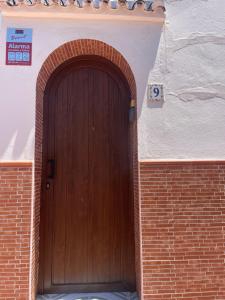 een houten deur aan de zijkant van een bakstenen gebouw bij Malaga Chalet en Guadalmar in Málaga