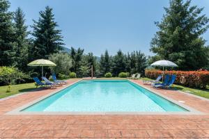 a swimming pool with two chairs and two umbrellas at Rifugio Arcobaleno in Popiglio