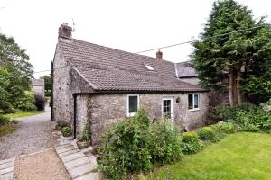 ein altes Steinhaus mit Garten davor in der Unterkunft Rose Cottage in Buxton