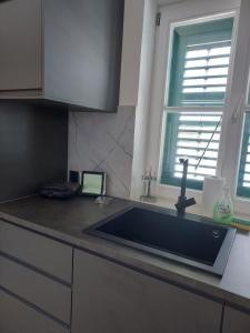 a kitchen counter with a sink and a window at Šuština in Tribunj +35 photos