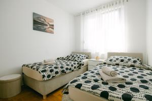 um quarto com 2 camas e uma janela em Ladenta apartman*** em Zagreb
