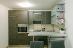 uma cozinha com armários cinzentos e um balcão branco em Ladenta apartman*** em Zagreb