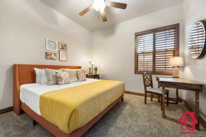 een slaapkamer met een bed, een bureau en een raam bij Bosque Retreat on the Rio - An Irvie Home in Albuquerque