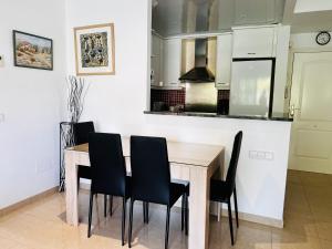 cocina con mesa de madera y sillas negras en Brises del Mar 3-3, en L'Estartit