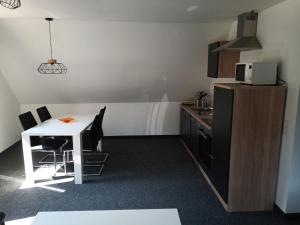 uma pequena cozinha com uma mesa branca e um micro-ondas em Ferienwohnung Waldblick - a88768 em Hattingen