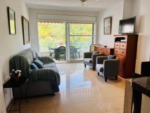 a living room with chairs and a desk and a television at Brises del Mar 3-3 in L'Estartit
