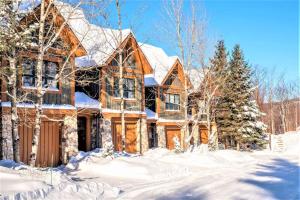 a house in the snow with snow covered trees at Tremblant Prestige - Équinoxe 164-2 in Mont-Tremblant +32 photos