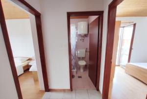 a room with a bathroom with a toilet and a mirror at Apartments Lidija in Lopar