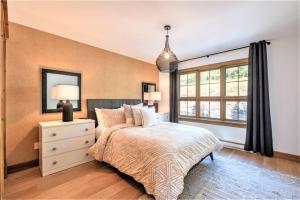 Un dormitorio con una cama grande y una ventana en Équinoxe 164-2 / Exclusive Mountain Home With View, en Mont-Tremblant