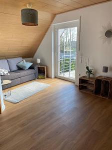 een woonkamer met een bank en een houten vloer bij Kleine gemütliche Wohnung in Coesfeld