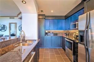 Una cocina con gabinetes azules y electrodomésticos de acero inoxidable. en Tremblant Prestige - Équinoxe 164-2, en Mont-Tremblant 32 fotos más