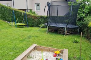 een tuin met een schommel en een trampoline bij Apartma pri babici in Slovenj Gradec