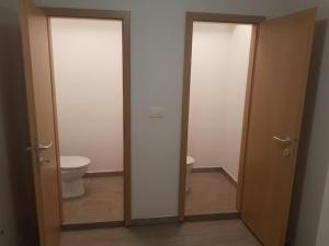 a bathroom with two doors and a toilet in it at Apartma pri babici in Slovenj Gradec +3 photos