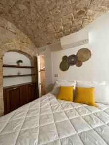 a bedroom with a large bed with yellow pillows at Longo Stone House in Castellana Grotte