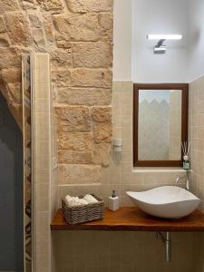 a bathroom with a sink and a mirror at Longo Stone House in Castellana Grotte