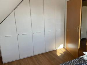 a bedroom with white cabinets and a bed at Kleine gemütliche Wohnung in Coesfeld