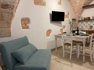 a living room with a table and a blue couch at Longo Stone House in Castellana Grotte