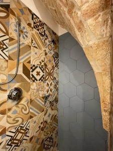 a bathroom with a shower with a tile wall at Longo Stone House in Castellana Grotte