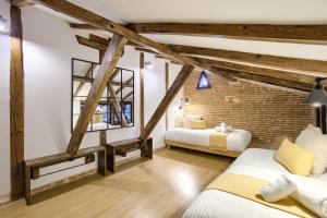 1 dormitorio con 2 camas y pared de ladrillo en Charming Madrid Serrano, en Madrid