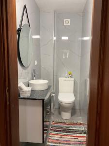 y baño con aseo, lavabo y espejo. en Cantinho Verde T2 en Geres