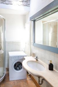 a bathroom with a washing machine and a sink at Rustic House, con patio e giardino, Assisi centro in Assisi