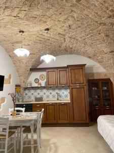 a kitchen with a table and a dining room at Longo Stone House in Castellana Grotte