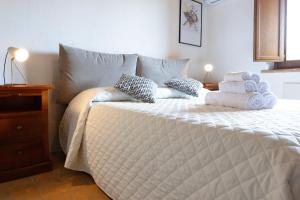 1 dormitorio con 1 cama con toallas en Rustic House, con patio e giardino, Assisi centro en Assisi