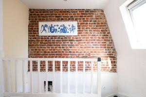 una pared de ladrillo con una pintura en la pared en Maison cosy 4 chambres, terrasse, garage privé en Croix
