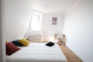 ein weißes Schlafzimmer mit einem großen weißen Bett und einem Fenster in der Unterkunft Maison cosy 4 chambres, terrasse, garage privé in Croix